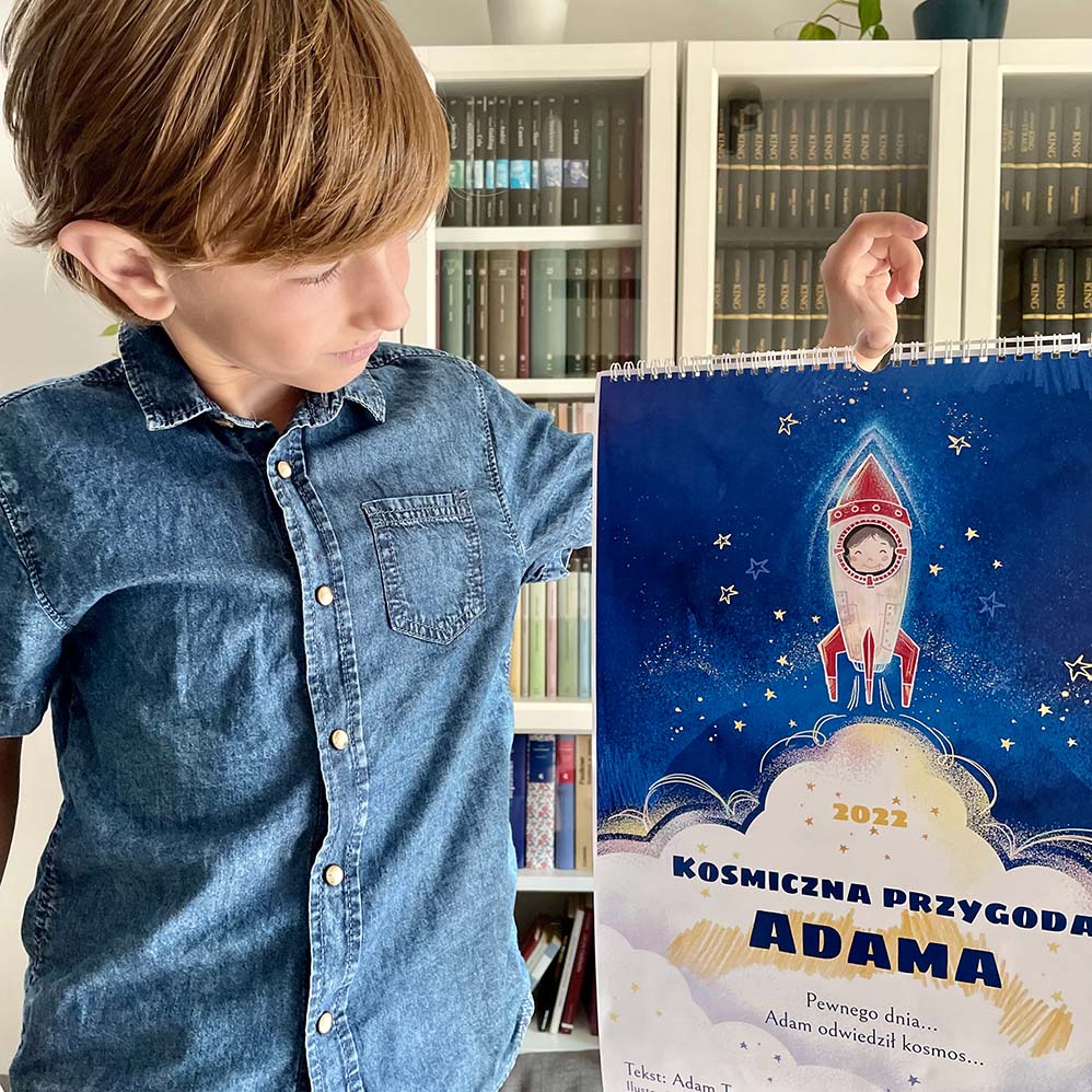 chłopiec trzyma swój kosmiczny ścienny kalendarz dla dzieci